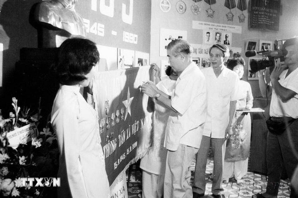 Đồng chí Đàm Quang Trung, Bí thư Trung ương Đảng, Phó Chủ tịch Hội đồng Bộ trưởng trao Huân chương Hồ Chí Minh của Chủ tịch nước tặng TTXVN tại Lễ kỷ niệm 45 năm Ngày thành lập (15/9/1945 - 15/9/1990). (Ảnh: Xuân Tuân/ TTXVN)