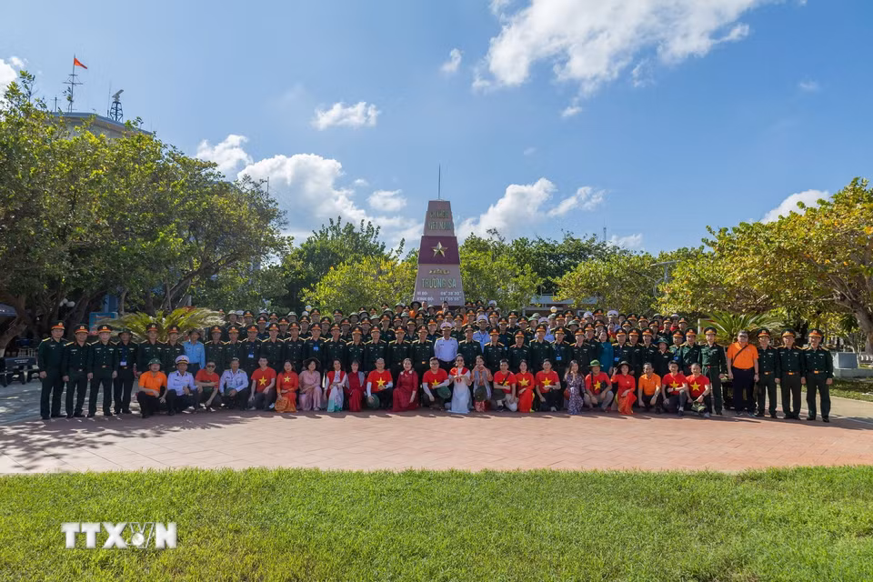 Đoàn công tác chụp ảnh lưu niệm trước cột mốc chủ quyền tại đảo Trường Sa. (Ảnh: Xuân Quý/TTXVN)