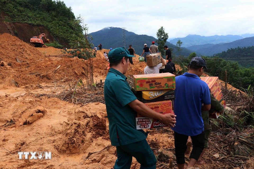 Lực lượng tại chỗ được huy động tối đa để mang vác lương thực, đi đường mòn trong rừng để tiếp cận các khu dân cư vùng sâu vùng xa (Ảnh: Đoàn Hữu Trung/TTXVN)