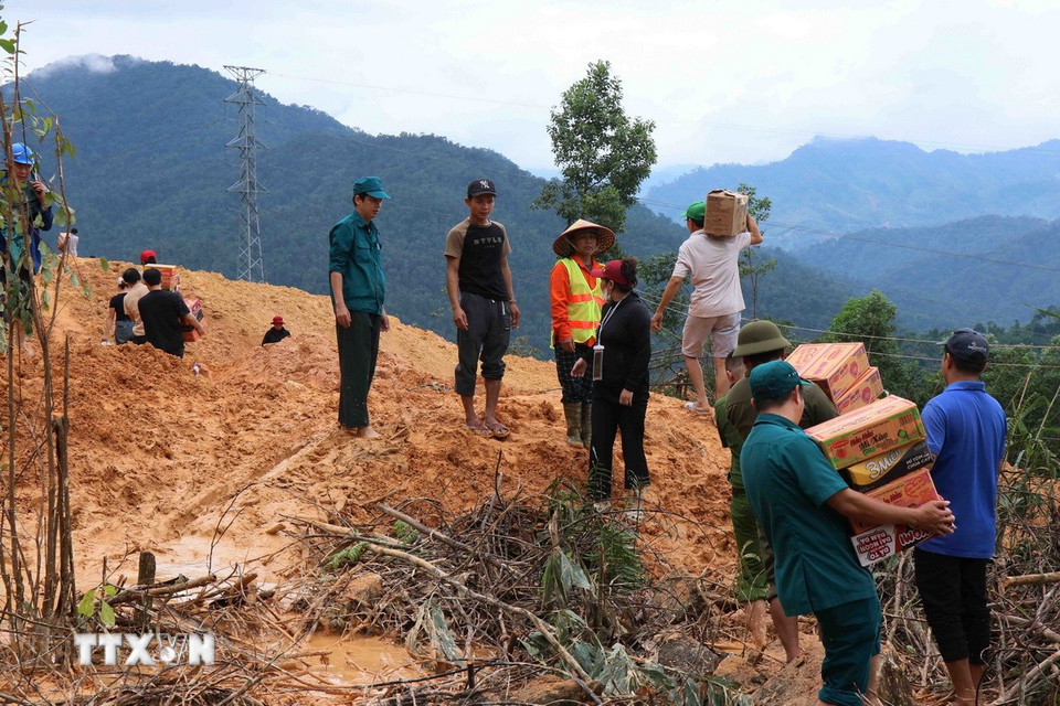 Tuyến Quốc lộ 40B bị sạt lở nặng, tuyến đường nối từ vùng đồng bằng về nhiều khu vực miền núi bị đình trệ hoàn toàn, hàng hóa tiếp tục được vận chuyển bằng sức người. (Ảnh: Đoàn Hữu Trung/TTXVN)