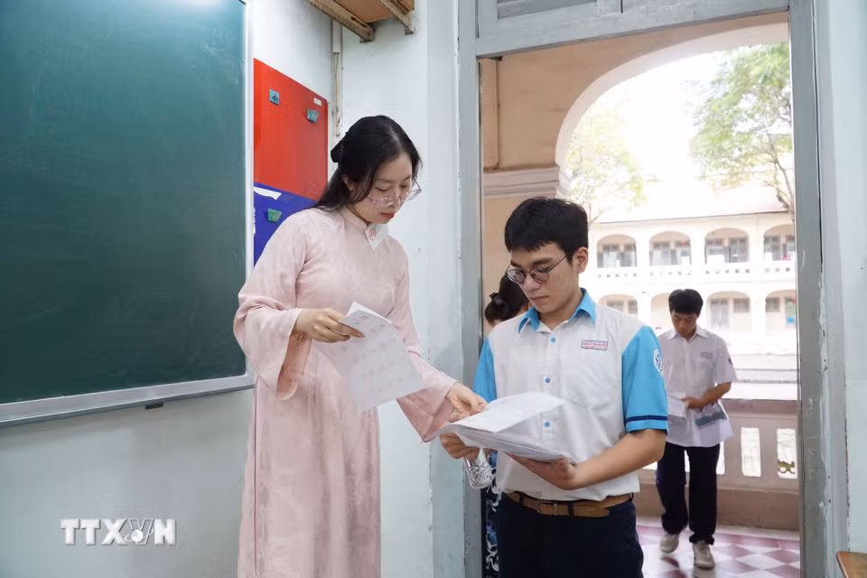 Cán bộ coi thi kiểm tra thông tin thí sinh trước khi vào phòng thi tại điểm thi Trường Trung học phổ thông chuyên Lê Hồng Phong. (Ảnh: Thu Hoài/TTXVN)