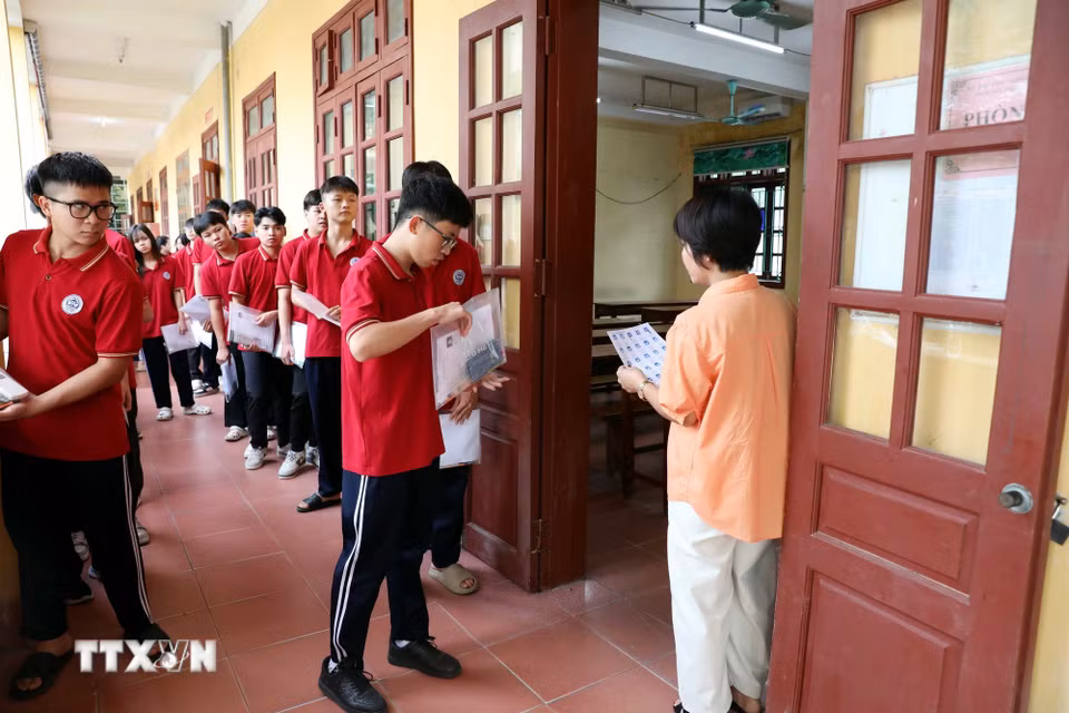 Cán bộ coi thi trường Trung học phổ thông Tân Trào, phường Minh Xuân (Tuyên Quang) kiểm tra, đối chiếu thông tin thí sinh trước khi vào phòng thi. (Ảnh: Quang Cường/TTXVN)