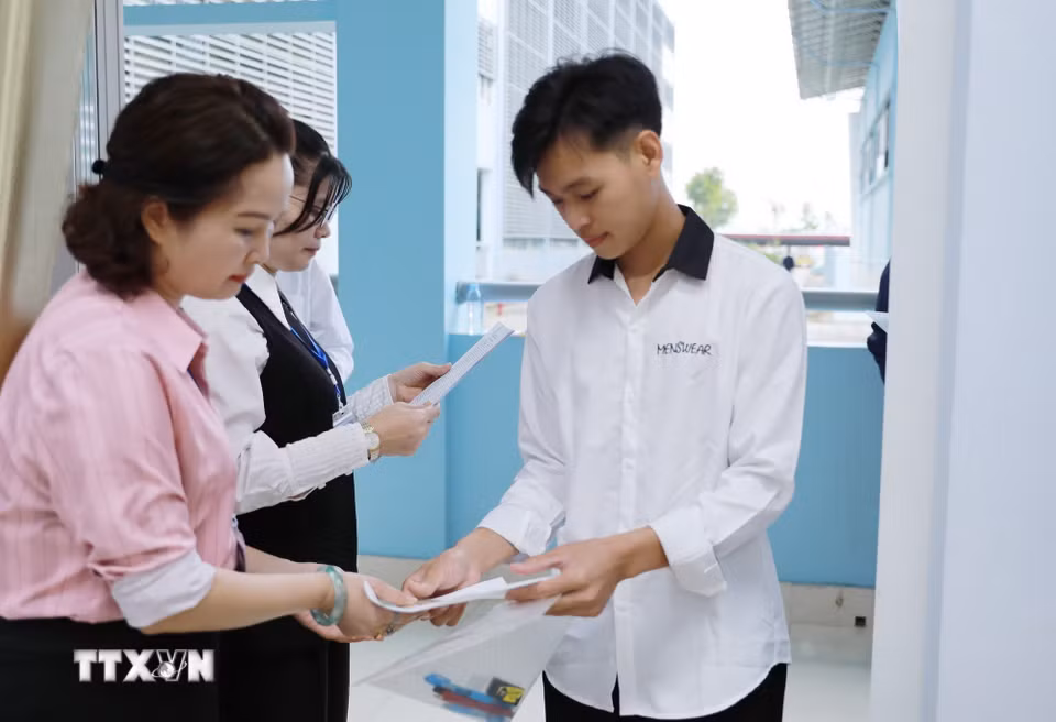 Giám thị gọi thí sinh vào phòng thi tại điểm thi Trường THPT Chuyên Lê Quý Đôn. (Ảnh: Quý Trung/TTXVN)