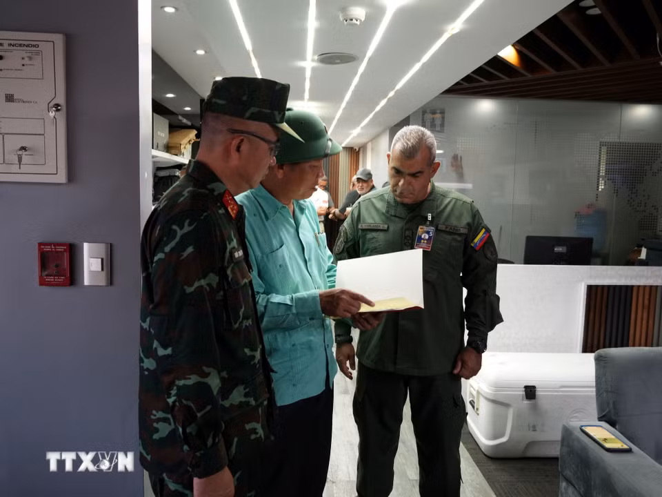 Đại sứ Việt Nam tại Venezuela trao thư của Bộ trưởng Quốc phòng Việt Nam cho đại diện lãnh đạo Bộ Quốc phòng Venezuela. (Ảnh: Phi Hùng/TTXVN)