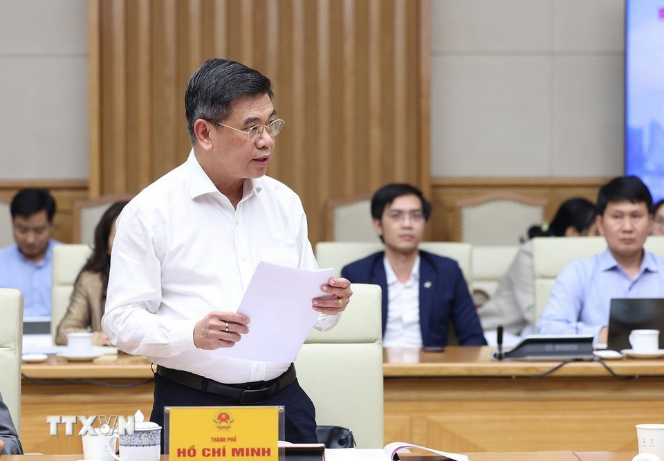 Phó Chủ tịch Ủy ban Nhân dân Thành phố Hồ Chí Minh Nguyễn Văn Dũng báo cáo tình hình triển khai Trung tâm tài chính quốc tế tại Thành phố Hồ Chí Minh. (Ảnh: Dương Giang/TTXVN)