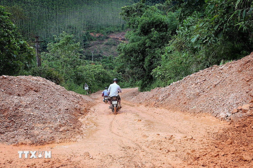 Người dân lưu thông hết sức khó khăn trên các con đường liên thôn, xóm nhầy nhụa bùn đất. (Ảnh: Thanh Hải/TTXVN)