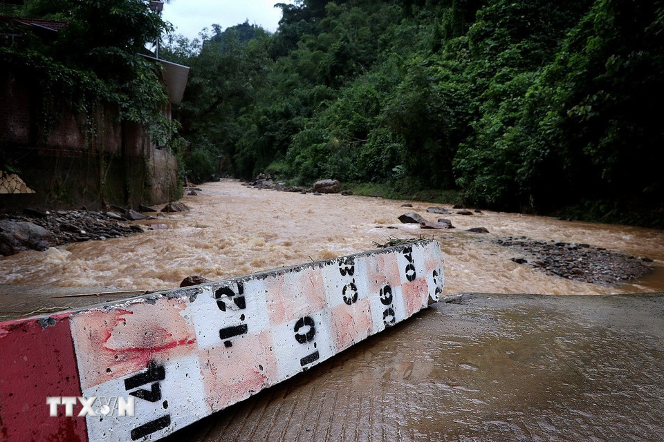 Nước lũ lớn đổ về tại ngầm suối Láo đã làm hư hỏng, đổ gẫy nhiều công trình giao thông. (Ảnh: Thanh Hải/TTXVN)