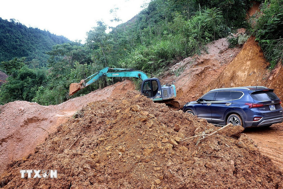 Lực lượng chức năng tạm thời xử lý các điểm sạt lở đường liên thôn, xóm để kết nối các xã bị cô lập. (Ảnh: Thanh Hải/TTXVN)