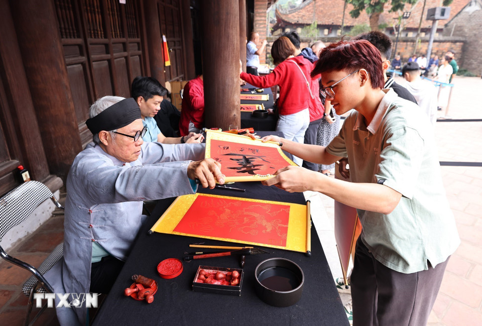 Người dân thủ đô xin chữ đầu năm tại Văn Miếu-Quốc Tử Giám (Hà Nội) là nét văn hóa truyền thống đặc sắc để cầu may mắn, trí tuệ và bình an. (Ảnh: Minh Đức/TTXVN)