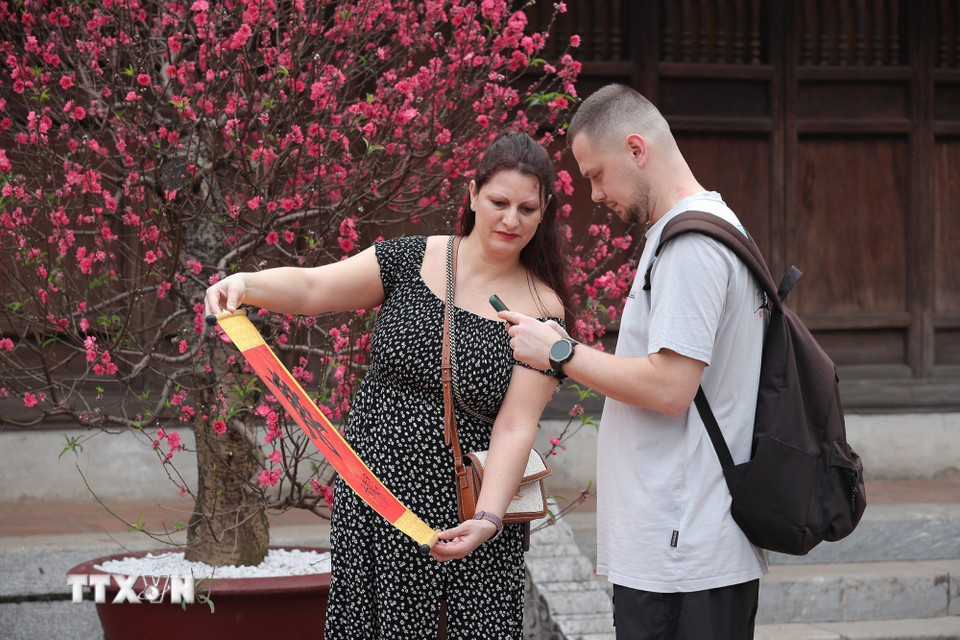 Du khách nước ngoài xin chữ đầu năm tại Văn Miếu-Quốc Tử Giám (Hà Nội) sáng Mùng 1 Tết Bính Ngọ. (Ảnh: Minh Đức/TTXVN)