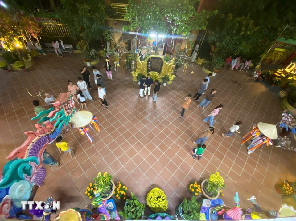 Người dân tề tựu trước sân chùa trong đêm giao thừa. (Ảnh: Nguyễn Hằng/TTXVN)