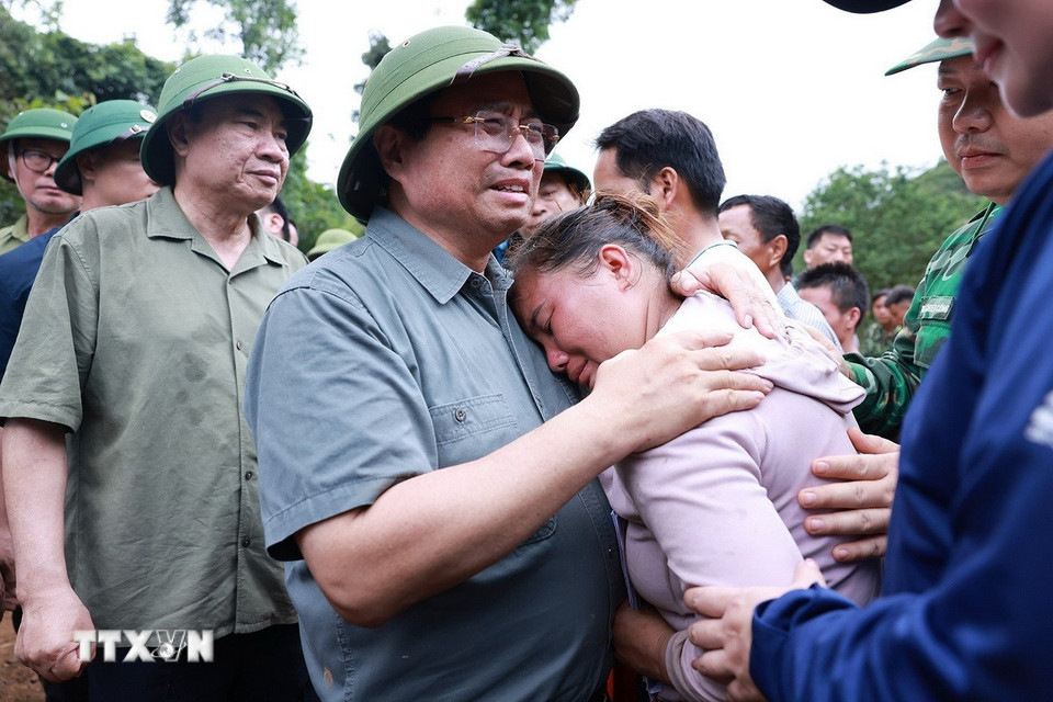 Thủ tướng Phạm Minh Chính động viên gia đình có người chết do mưa lũ ở xã Xa Dung. (Ảnh: Dương Giang/TTXVN)