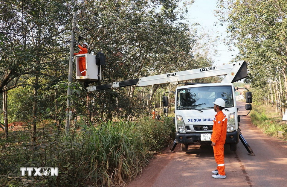 Công nhân Đội Điện lực Đồng Phú thi công lắp đặt đèn chiếu sáng năng lượng mặt trời tại thôn Tân Tiến, xã Đồng Phú, tỉnh Đồng Nai. (Ảnh: Đậu Tất Thành/TTXVN)