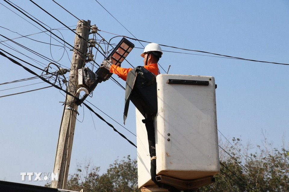 Công nhân Đội Điện lực Đồng Phú thi công lắp đặt đèn chiếu sáng năng lượng mặt trời tại thôn Tân Tiến, xã Đồng Phú, tỉnh Đồng Nai. (Ảnh: Đậu Tất Thành/TTXVN)