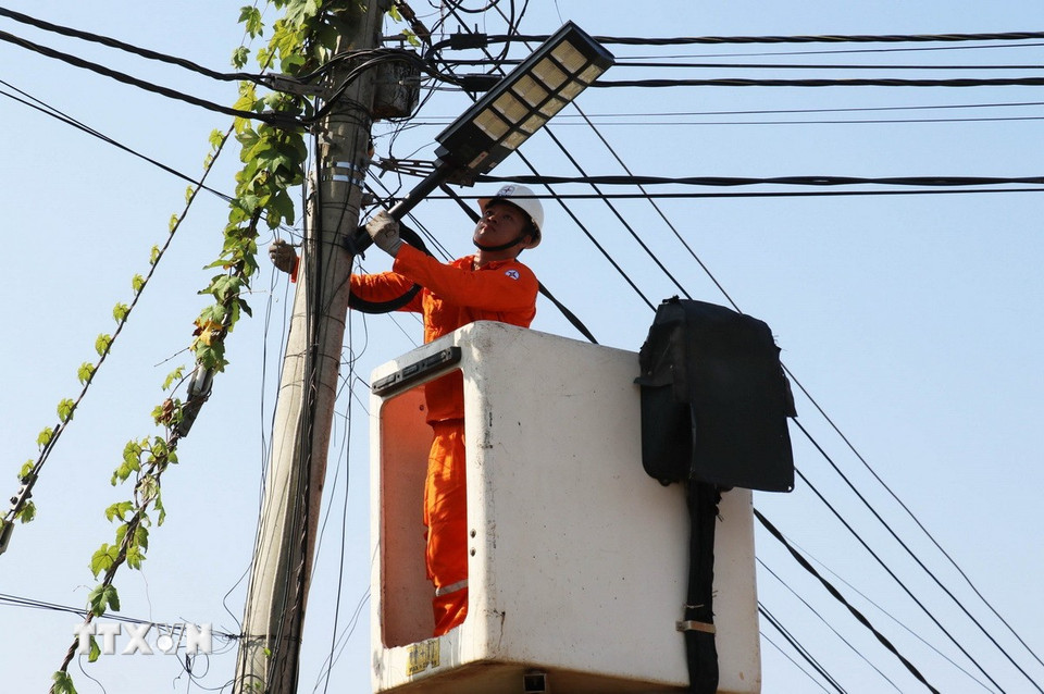 Công nhân Đội Điện lực Đồng Phú thi công lắp đặt đèn chiếu sáng năng lượng mặt trời tại thôn Tân Tiến, xã Đồng Phú, tỉnh Đồng Nai. (Ảnh: Đậu Tất Thành/TTXVN)