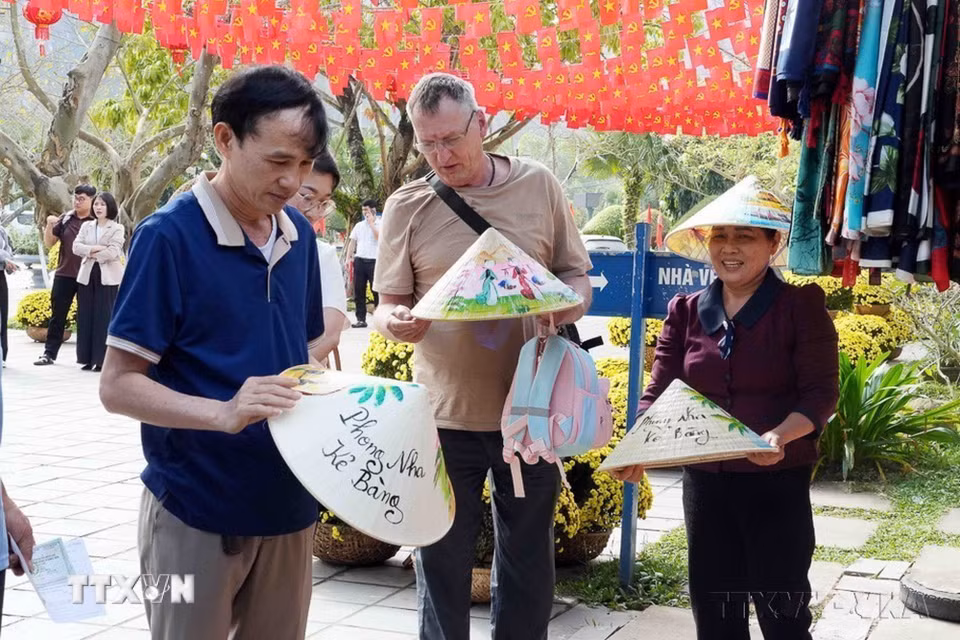 Du khách chọn mua các mặt hàng lưu niệm khi tham quan Phong Nha-Kẻ Bàng dịp đầu xuân năm mới. (Ảnh: Tá Chuyên/TTXVN)