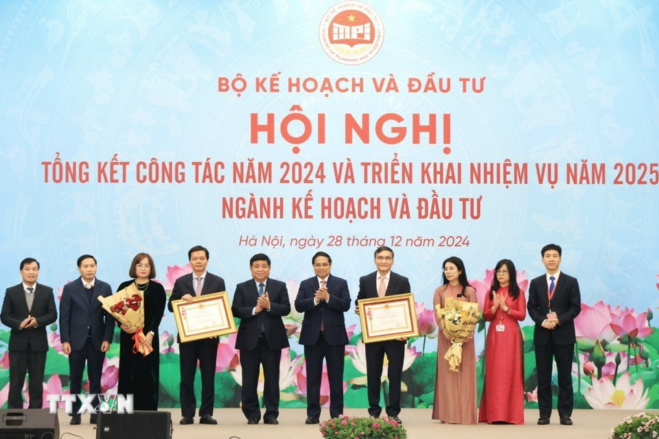 Thủ tướng Phạm Minh Chính và Bộ trưởng Bộ Kế hoạch và Đầu tư Nguyễn Chí Dũng trao Huân chương Lao động hạng Ba cho các tập thể. (Ảnh: Tuấn Anh/TTXVN)