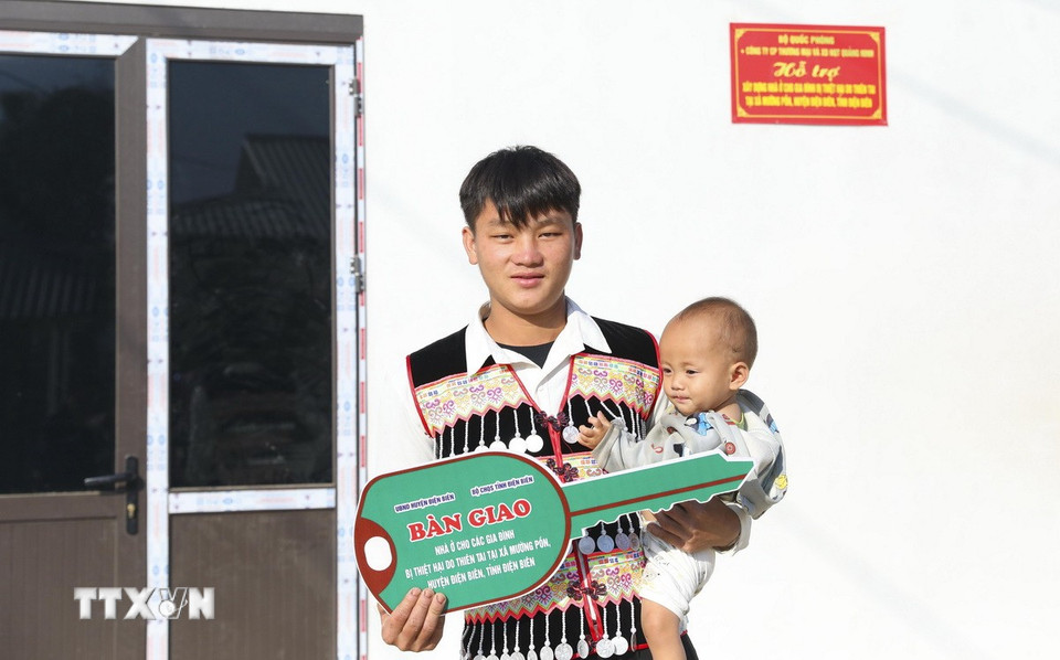 Anh Sùng A Lạ và con trai phấn khởi nhận nhà mới tại điểm dân cư Huổi Ké, xã Mường Pồn. (Ảnh: Xuân Tư/ TTXVN)