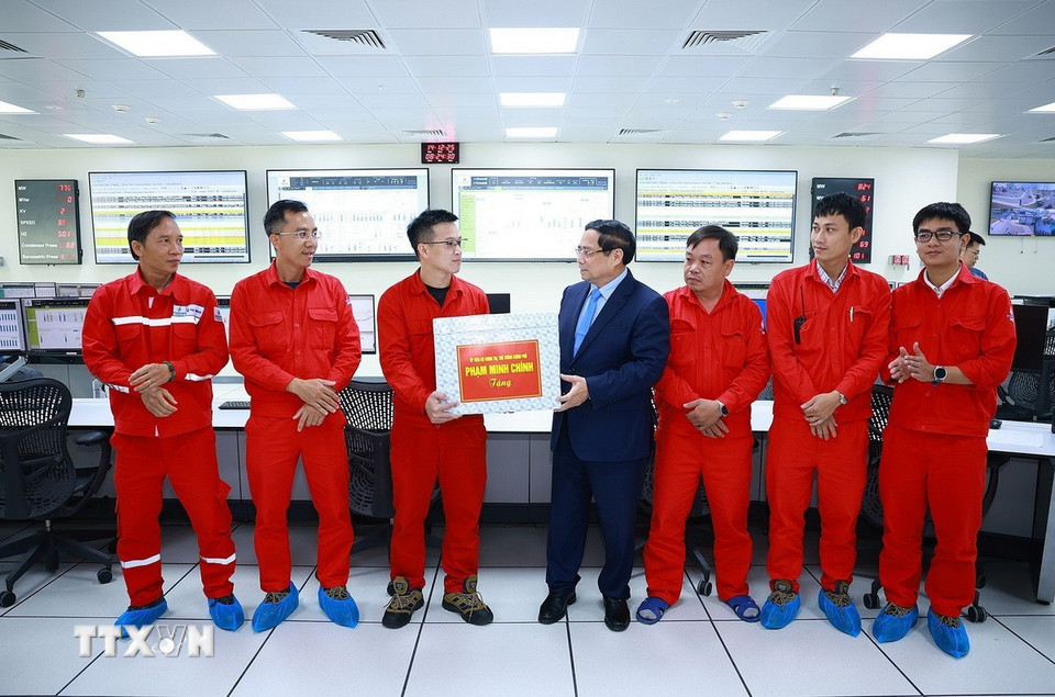 Thủ tướng Phạm Minh Chính tặng quà cho kỹ sư, chuyên gia điều hành Nhà máy điện LNG Nhơn Trạch 3 và 4. (Ảnh: Dương Giang/TTXVN)