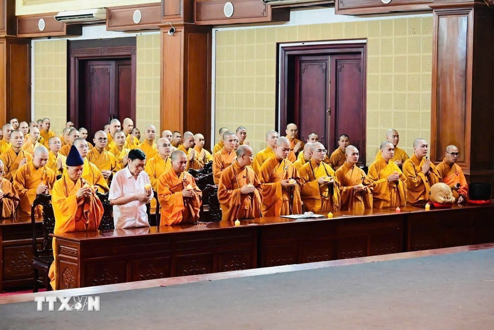 Các chư tăng, cư sỹ thắp nến cầu nguyện quốc thái dân an. (Ảnh: TTXVN phát)