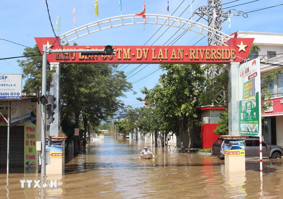 Người dân sử dụng xuồng để di chuyển trong khu dân cư. (Ảnh: Hồng Hiếu/TTXVN)