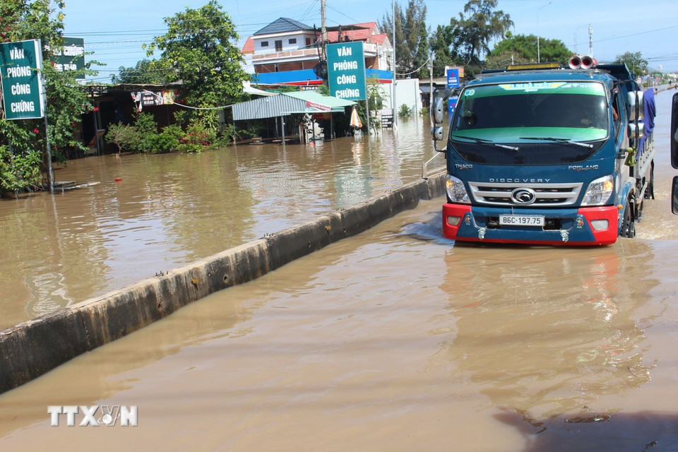 Tuyến quốc lộ 1A qua địa bàn phường Hàm Thắng bị ngập sâu trong nước lũ. (Ảnh: Hồng Hiếu/TTXVN)