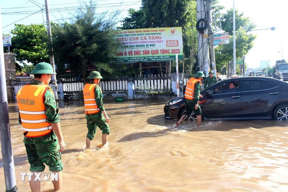 Lực lượng bộ đội Đồn biên phòng Thanh Hải hỗ trợ người dân lưu thông qua tuyến đường Nguyễn Thông, phường Phú Thủy (Lâm Đồng). (Ảnh: Hồng Hiếu/ TTXVN)