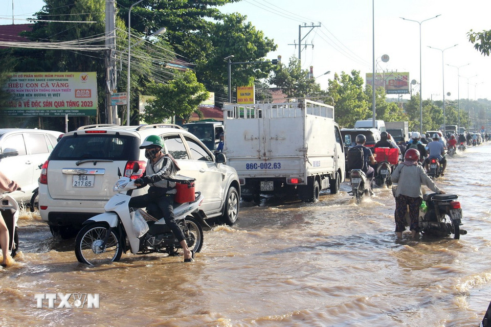 Các phương tiện lưu thông khó khăn trên tuyến đường Nguyễn Thông (phường Phú Thủy, tỉnh Lâm Đồng) do ngập sâu. (Ảnh: Hồng Hiếu/ TTXVN)
