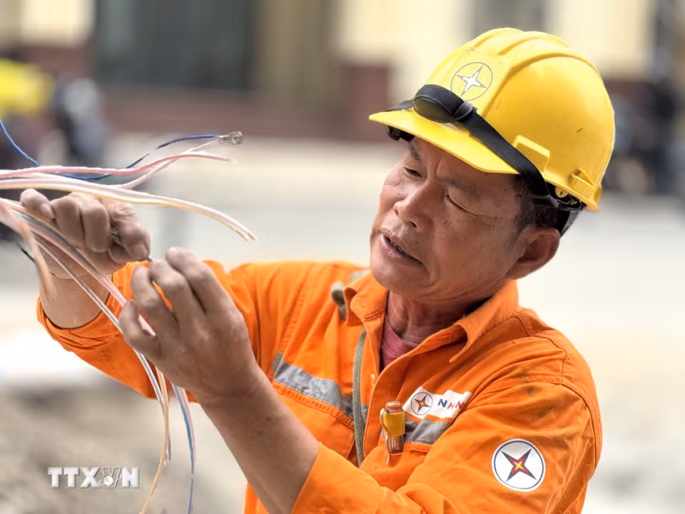 Người lao động phải làm việc ngoài trời dưới nền nhiệt gần 40 độ C. (Ảnh: Quốc Lũy/ TTXVN)