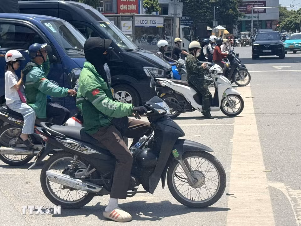 Trên các tuyến đường, người tham gia giao thông vất vả di chuyển dưới hơi nóng hầm hập phả lên từ mặt đường. (Ảnh: Quốc Lũy/TTXVN)