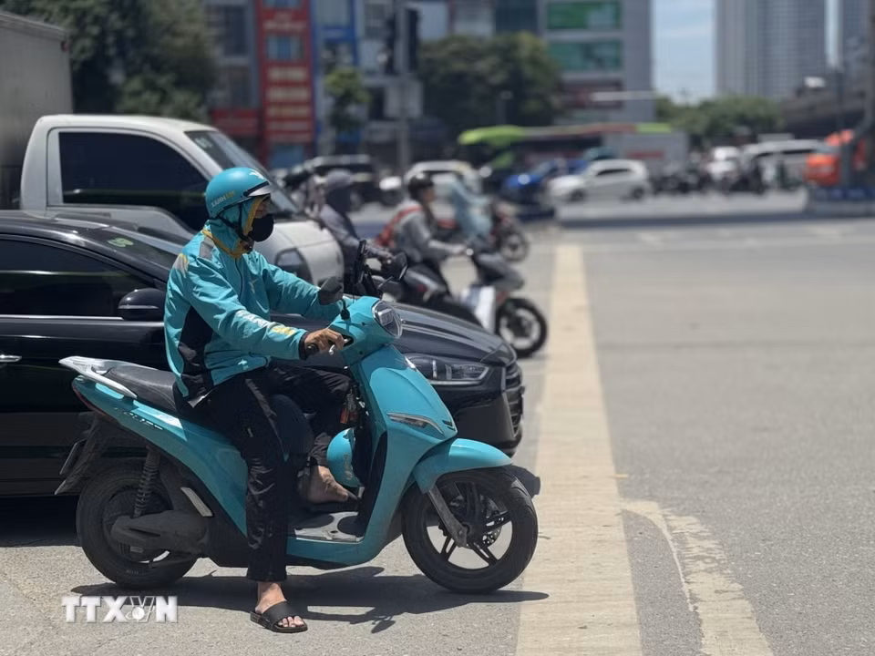 Trên các tuyến đường, người tham gia giao thông vất vả di chuyển dưới hơi nóng hầm hập phả lên từ mặt đường. (Ảnh: Quốc Lũy/TTXVN)