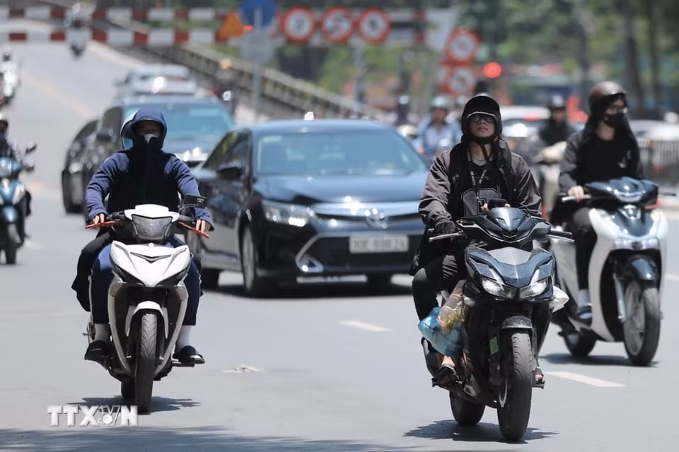 Người dân khi ra đường cần trang bị khăn, mũ, áo chống nắng. (Ảnh: Minh Quyết/TTXVN)