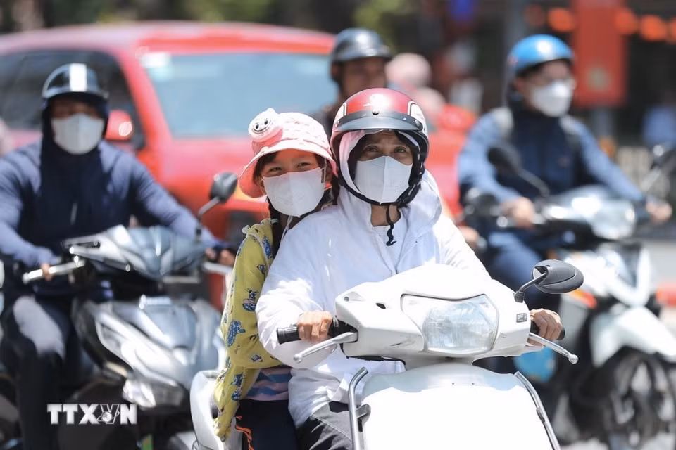 Người dân khi ra đường cần trang bị khăn, mũ, áo chống nắng. (Ảnh: Minh Quyết/TTXVN)