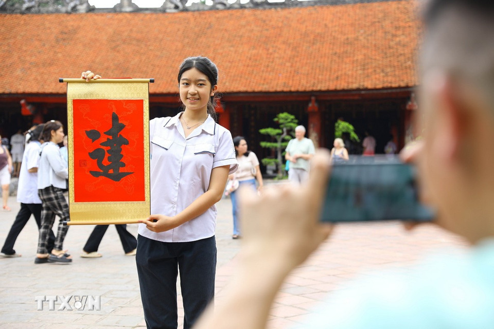 Phụ huynh và thí sinh đến Văn Miếu-Quốc Tử Giám cầu may mắn và xin chữ “Đạt” trước kỳ tuyển sinh vào lớp 10. (Ảnh: Lê Đông/TTXVN)