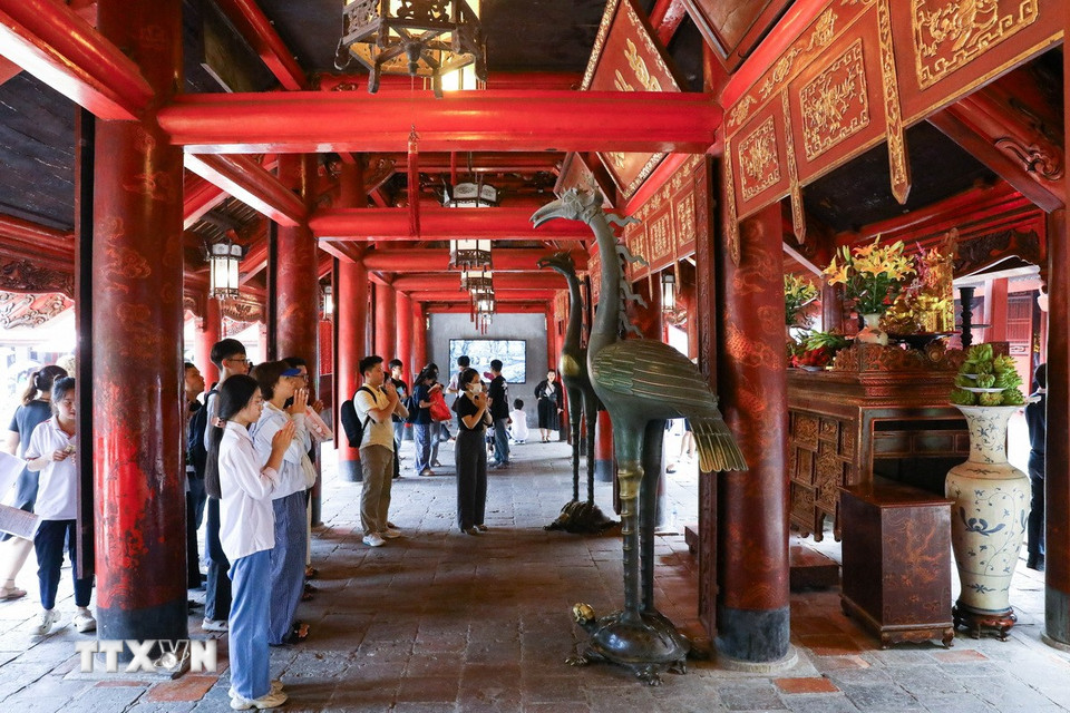 Thí sinh và người nhà dâng hương cầu may tại Văn Miếu-Quốc Tử Giám. (Ảnh: Lê Đông/TTXVN)