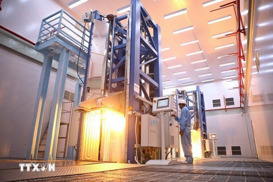 Công nhân công ty Cổ phần Thiết bị Bưu điện vận hành dây chuyền sản xuất chính (tháp kéo sợi) do NEXTROM (Phần Lan) cung cấp. Đây là tháp kéo sợi quang cao nhất tính đến thời điểm này, với tốc độ 3.000m sợi/1 phút. (Ảnh: Minh Quyết/TTXVN)