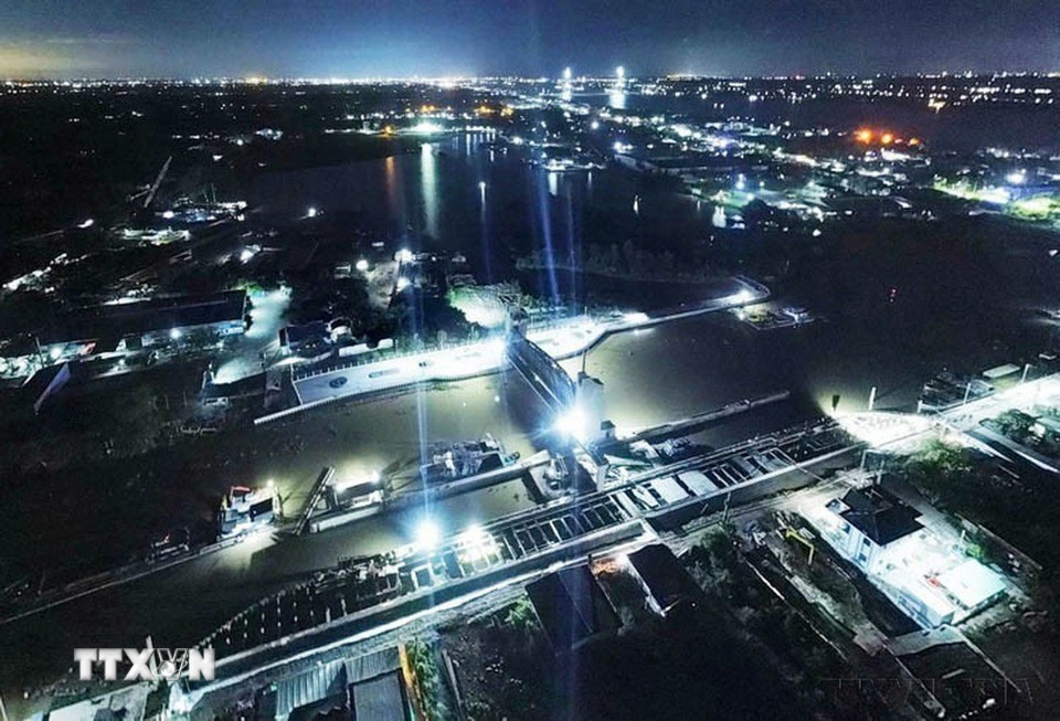 Công nhân trên công trình Cống ngăn mặn Nguyễn Tấn Thành ở huyện Châu Thành (Tiền Giang) làm việc xuyên đêm để đảm bảo tiến độ công trình. (Ảnh: TTXVN phát)