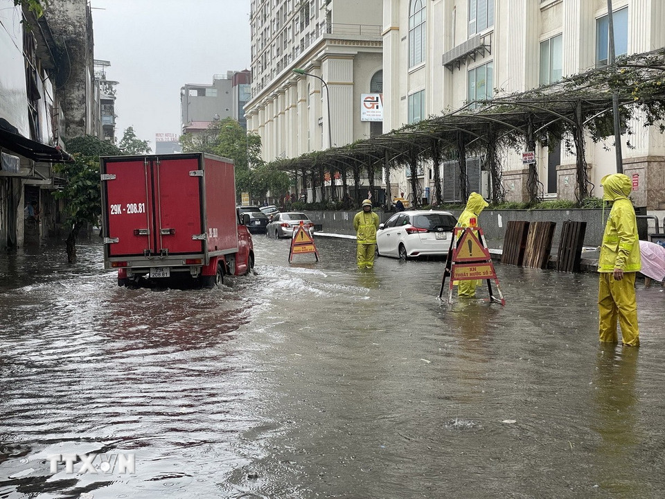 Nước ngập đến quá nửa bánh xe trên phố Mạc Thị Bưởi. (Ảnh: Trần Việt/TTXVN)