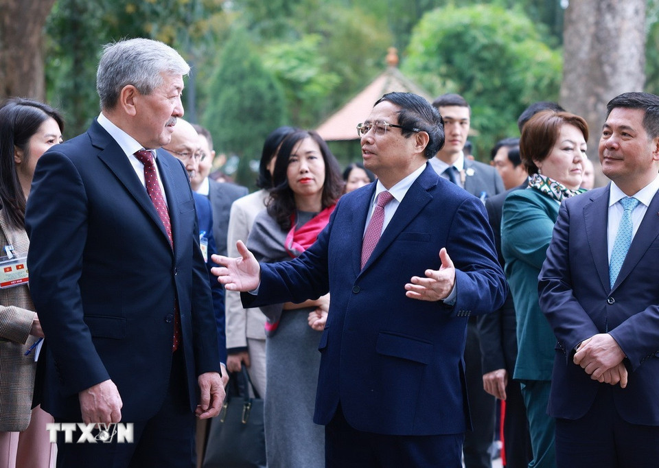 Thủ tướng Phạm Minh Chính giới thiệu với Thủ tướng Kyrgyzstan Adylbek Kasymaliev Di tích Nhà sàn Bác Hồ. (Ảnh: Dương Giang/TTXVN)