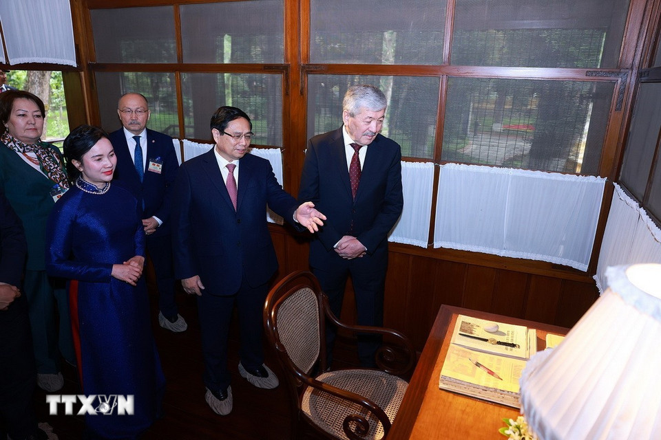 Thủ tướng Phạm Minh Chính giới thiệu với Thủ tướng Kyrgyzstan Adylbek Kasymaliev nơi Bác Hồ ở và làm việc. (Ảnh: Dương Giang/TTXVN)