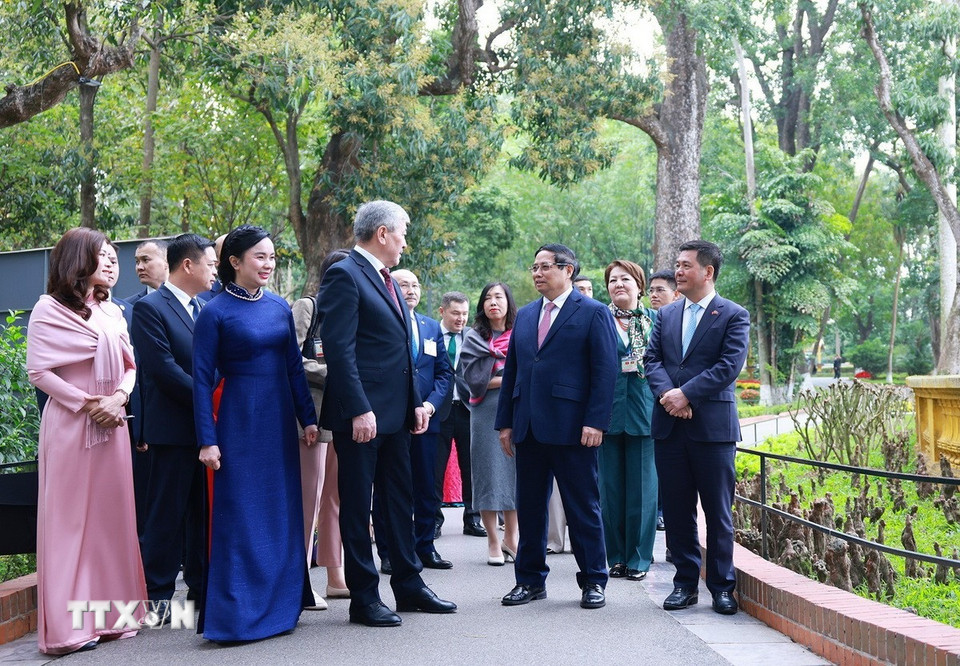 Thủ tướng Phạm Minh Chính giới thiệu với Thủ tướng Kyrgyzstan Adylbek Kasymaliev Di tích Nhà sàn Bác Hồ. (Ảnh: Dương Giang/TTXVN)