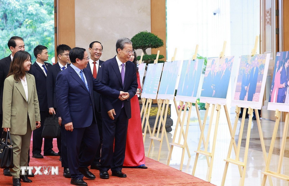 Thủ tướng Phạm Minh Chính và Ủy viên trưởng Nhân đại toàn quốc Trung Quốc Triệu Lạc Tế tham quan trưng bày Ảnh về quan hệ hợp tác giữa hai nước do TTXVN thực hiện. (Ảnh: Dương Giang/TTXVN)