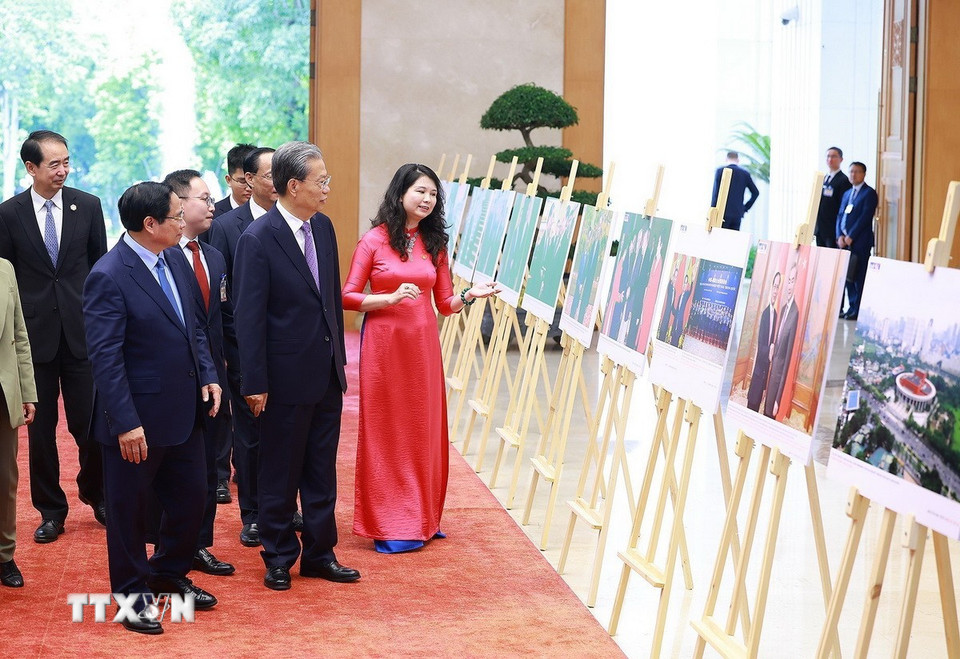 Thủ tướng Phạm Minh Chính và Ủy viên trưởng Nhân đại toàn quốc Trung Quốc Triệu Lạc Tế tham quan trưng bày Ảnh về quan hệ hợp tác giữa hai nước do TTXVN thực hiện. (Ảnh: Dương Giang/TTXVN)