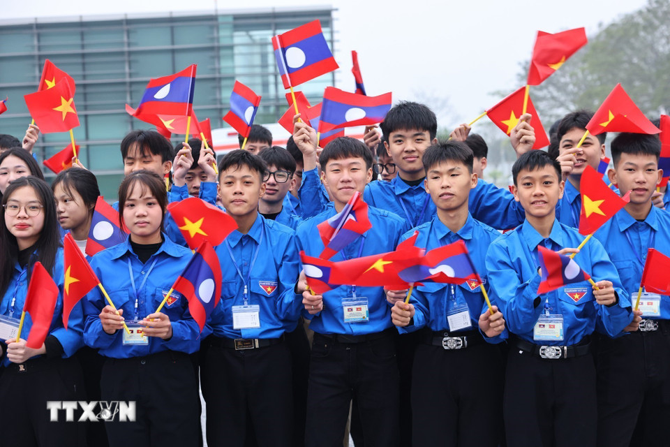 Học sinh, sinh viên thủ đô đón Tổng Bí thư Ban Chấp hành Trung ương Đảng Nhân dân cách mạng Lào, Chủ tịch nước Cộng hòa Dân chủ Nhân dân Lào Thongloun Sisoulith và Phu nhân tại sân bay Quốc tế Nội Bài. (Ảnh: Minh Đức/TTXVN)