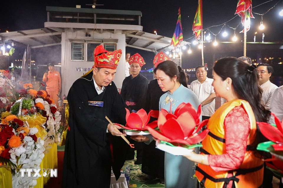 Các đại biểu thực hiện nghi thức lấy lửa đèn hoa đăng. (Ảnh: Trọng Đạt/TTXVN)