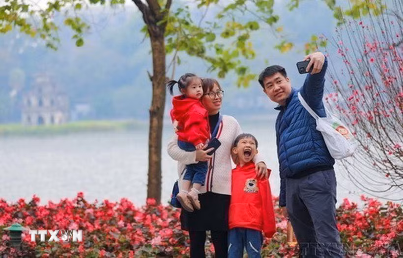 Một gia đình cùng nhau ghi lại khoảnh khắc của mùa Xuân bên hồ Gươm. (Ảnh: Thanh Tùng/TTXVN)