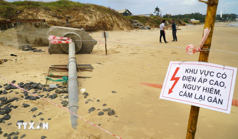 Ngành chức năng chăng dây, cắm biển cảnh báo nguy hiểm tại vị trí cáp ngầm 22kV lộ thiên còn mang điện. (Ảnh: Lê Phước Ngọc/TTXVN)