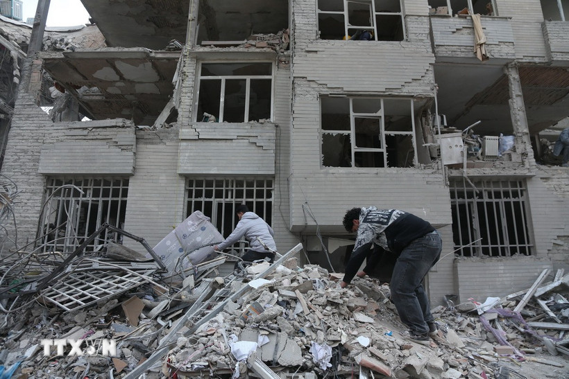 Người dân tìm kiếm đồ đạc trong đống đổ nát của những tòa nhà bị phá hủy sau các cuộc tấn công tại Tehran, Iran, ngày 12/3/2026. (Ảnh: THX/TTXVN)