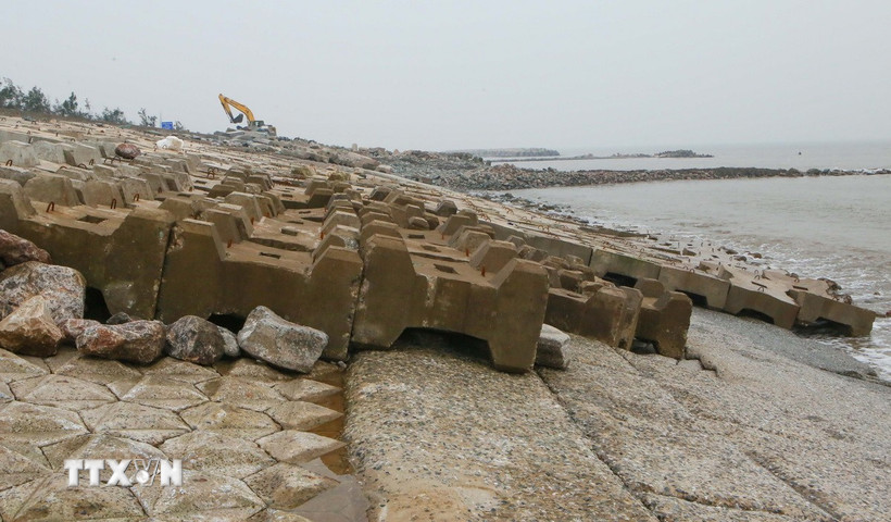 Các cấu kiện bê tông vững chắc được xếp đè lên mái đê nhằm tránh vị trí sạt sập lan rộng khi thủy triều lên xuống. (Ảnh: Công Luật/TTXVN)