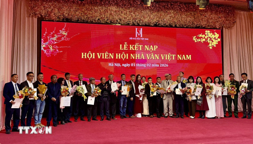 Đại diện Ban chấp hành Hội Nhà văn Việt Nam trao quyết định kết nạp hội viên mới. (Ảnh: Phương Lan/TTXVN)